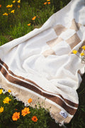 North Star Blanket spread on vibrant flowers in a natural setting, showcasing its design and material.
