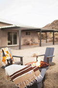 North Star Blanket draped over a chair beside a fire pit in an outdoor setting.