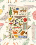 Oregon Kitchen & Tea Towel with Oregon icons like a deer, covered wagon, whale, crab and trout on cream