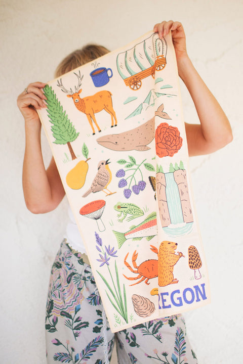 Oregon Kitchen & Tea Towel showcasing vibrant designs with nature illustrations, perfect for drying dishes.