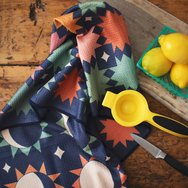 Moon Phase Kitchen & Tea Towel with vibrant double-sided design, eco-friendly and super absorbent, displayed on wooden tabletop.