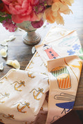Rhode Island Kitchen & Tea Towel with vibrant anchor, lighthouse, and fish designs on a table.