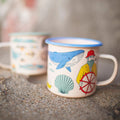 Salty Seas Enamel Mug 16oz with nautical design featuring a whale and sailor, perfect for campfires and cozy mornings.