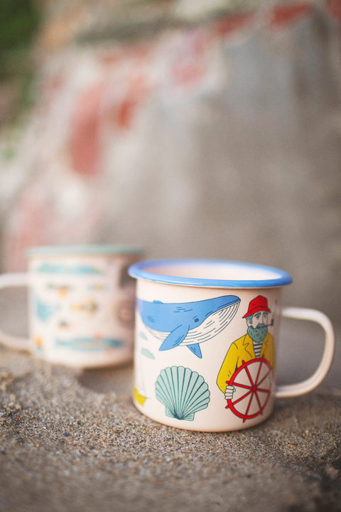 Salty Seas Enamel Mug 16oz with nautical design featuring a whale and sailor, perfect for campfires and cozy mornings.