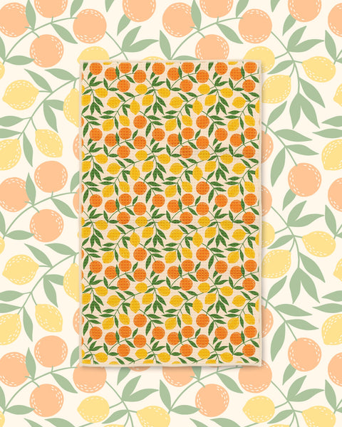 Saved By Citrus Kitchen & Tea Towel with oranges and lemons among green leaves on a cream background