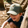 Child wearing a Silly Goose Kids Hat while playing outdoors, smiling and enjoying a sunny day.