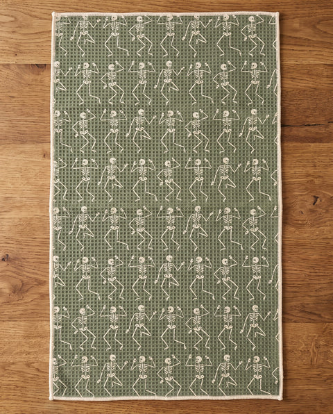 Skeleton Party waffle kitchen tea towel reverse side laid flat: sage-green with cream dancing skeletons