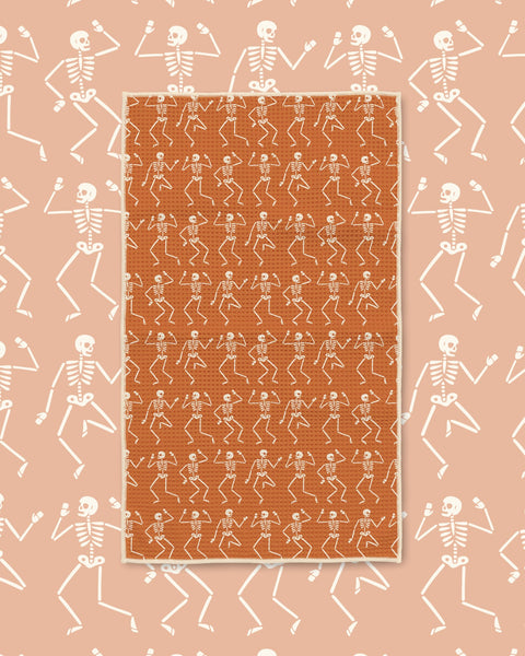 Skeleton Party Kitchen & Tea Towel with rows of white dancing skeletons on an orange background