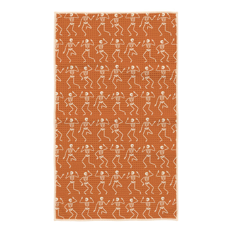 Burnt orange kitchen tea towel with cream dancing skeleton pattern and hanging loop