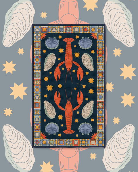 Snug Harbor Kitchen & Tea Towel with red lobsters, oysters and shells inside a colorful tiled border on navy