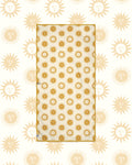 Sunny Wander & Travel Towel in cream with gold sun face print and gold trim, laid flat on a matching sun pattern background.