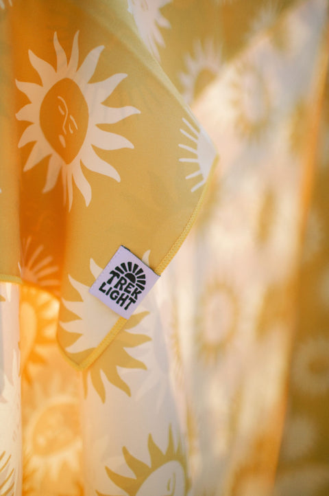Sunny Wander & Travel Towel featuring a sunny design and TREK LIGHT tag. Perfect for travel and outdoor use.