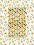 Yellow and green black-eyed Susan pattern towel laid flat over a matching daisy print background