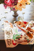 Texas Kitchen & Tea Towel featuring vibrant designs on a table with a glass of wine.