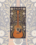 Travelin' Light Wander & Travel Towel with an orange guitar and olive vines on dark plum, over a gray floral backdrop