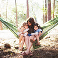 Double Hammock & Pro Hanging Straps (River Trout Print) with a mother and two children enjoying outdoor relaxation.