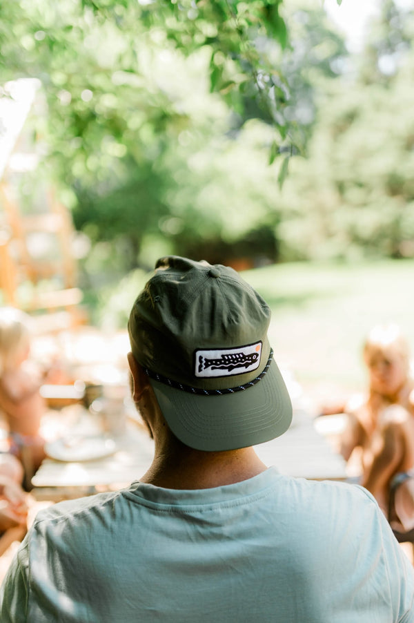 Person wearing a Trout Hat (Olive) while enjoying time outdoors with friends.