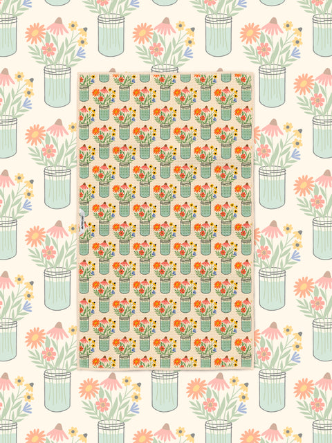 Wildflower mason jar pattern kitchen towel styled over a matching floral illustrated backdrop