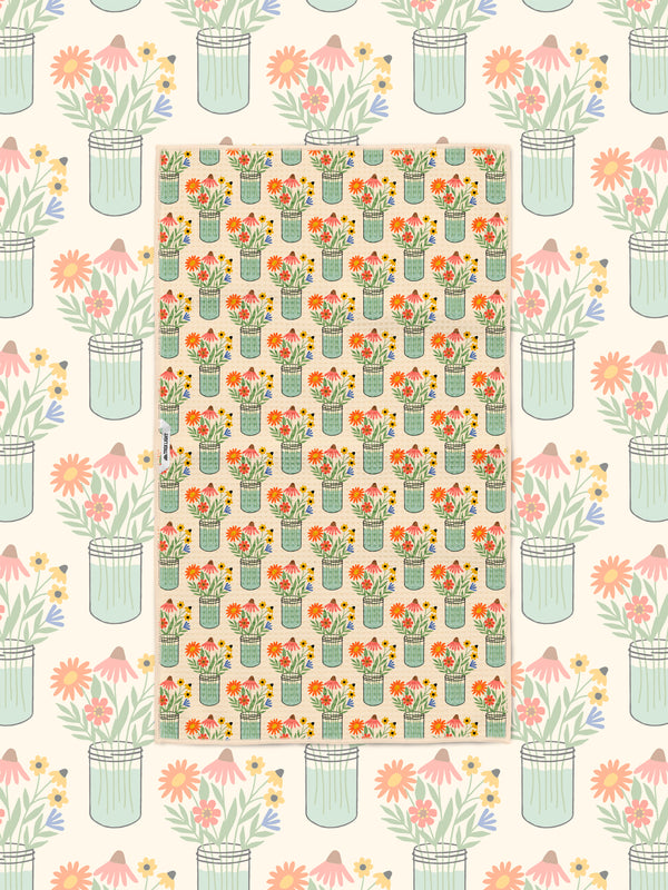 Wildflower mason jar pattern kitchen towel styled over a matching floral illustrated backdrop