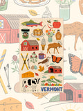 Vermont icon kitchen towel styled over a matching illustrated backdrop of barns, butterflies and fall leaves