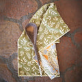 Wavy Flowers Kitchen & Tea Towel with a wooden spoon on a rustic background.