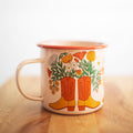 Western Bloom Enamel Mug 16oz with floral boot design by Trek Light on a wooden table, perfect for cozy sips.