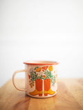 Western Bloom Enamel Mug 16oz with floral boot design by Trek Light on a wooden table, perfect for cozy sips.