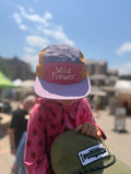 Child wearing a colorful Wild Flower Kids Hat outdoors, perfect for sunny days and adventures.