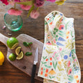 Wildflower Wonder Kitchen & Tea Towel on wooden surface with lemons and limes, showcasing its vibrant, eco-friendly design.