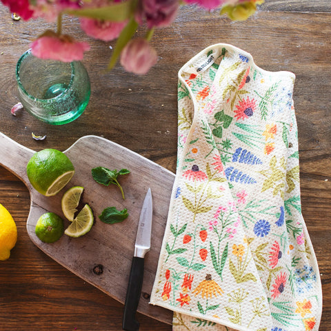 Wildflower Wonder Kitchen & Tea Towel on wooden surface with lemons and limes, showcasing its vibrant, eco-friendly design.