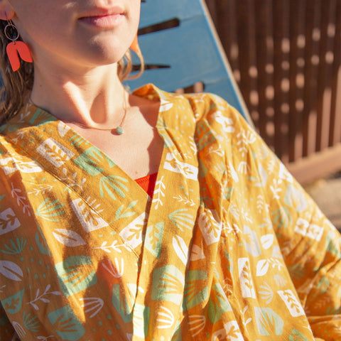 Person relaxing outdoors in a cozy Agave Robe with colorful patterns, reflecting Trek Light's unisex style and eco-friendly ethos.