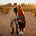 Couple wrapped in handwoven Arizona Blanket by Trek Light. Cozy and beautiful, against a Southwest sunset, made from recycled materials.