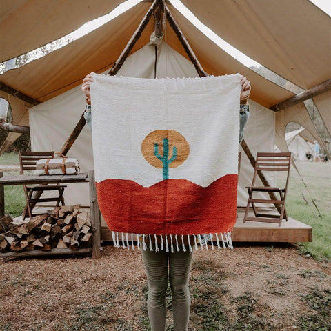 Person holding Trek Light Arizona Blankestry featuring a desert scene with cactus, perfect for decor or cozy use in any setting.