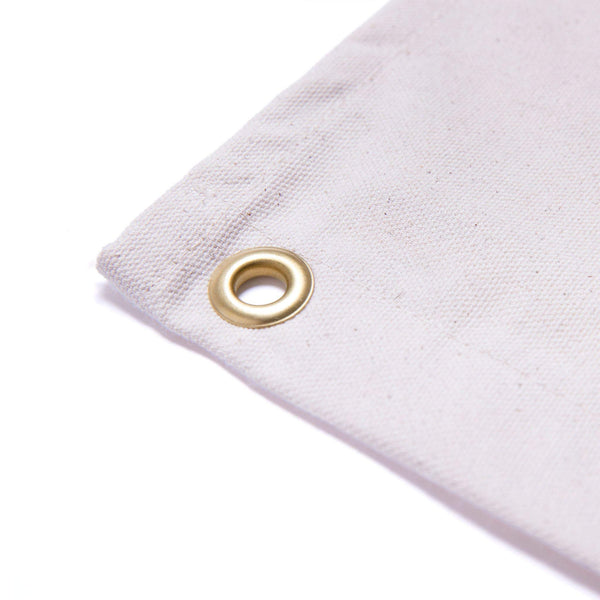 Close-up of a brass grommet on a natural canvas flag for easy hanging, part of the Trek Light Mountain Therapy collection.