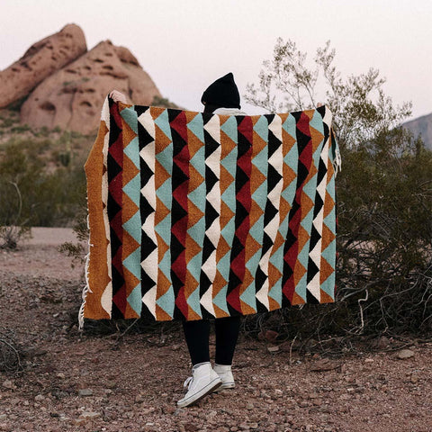 Cozy Cascade Blanket handwoven from recycled clothing materials, featuring beautiful geometric patterns in a versatile outdoor setting. By Trek Light.