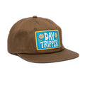 Brown Day Tripper hat with flat brim, featuring Trek Light patch and stylish vent holes for breathable comfort. Perfect for adventures!