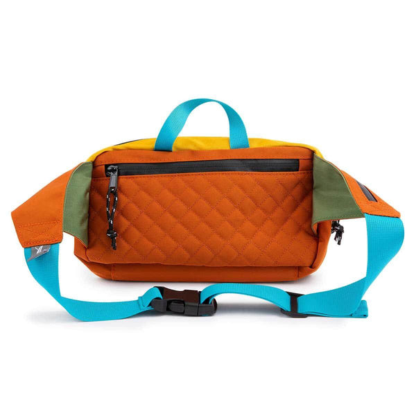 Trek Light Everyday Fanny Pack in Cypress, versatile hip or shoulder sling bag with vibrant orange and blue straps.