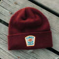 Flower Child Kids Beanie by Trek Light on wooden background, perfect for the free spirit in all of us.