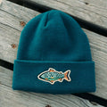 Go Outdoors Kids Beanie on wooden surface, featuring a fish patch with 'Go Outdoors' text, perfect for Trek Light adventures.