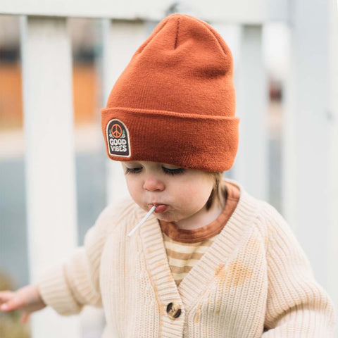 Little adventurer wearing a Good Vibes Kids Beanie by Trek Light, enjoying a sweet moment outdoors. Perfect for spreading smiles!