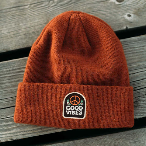 Cozy Good Vibes Kids Beanie on wooden surface, perfect for spreading joy. Trek Light style for happy adventures!