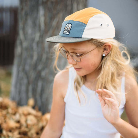 Child wearing a 5-panel snapback Good Vibes kids hat by Trek Light with a flat brim, 100% cotton, enjoying outdoor play.