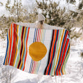 Person holding colorful Halley's Comet Blanket by Trek Light in snowy outdoors