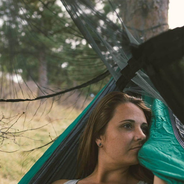 Woman relaxing in a hammock with the Trek Light Bug Free Hammock Shield, enjoying the outdoors free from pesky bugs.