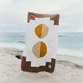 Trek Light Horizon Blanket handwoven with recycled materials featuring unique design displayed on a beach.