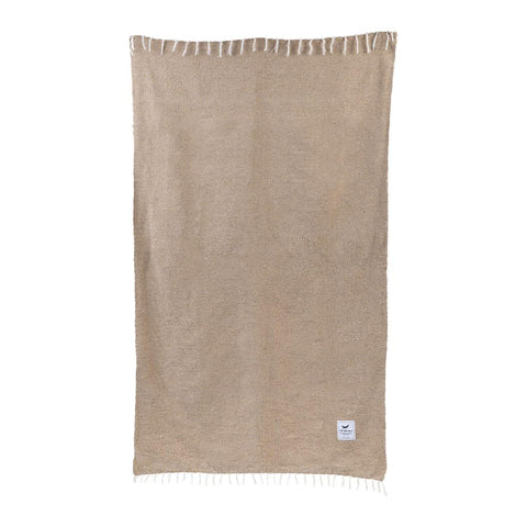 Handwoven blanket from Trek Light, made with 100% recycled materials, featuring a neutral design and sustainable craftsmanship. Eco-friendly choice.