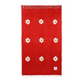 Lazy Daisy Blanket by Trek Light, featuring white daisy patterns on a vibrant red background, perfect for slow, relaxing moments.