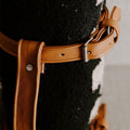 Close-up of Trek Light blanket with handcrafted leather carrier strap, showcasing stylish outdoor gear made from recycled materials.