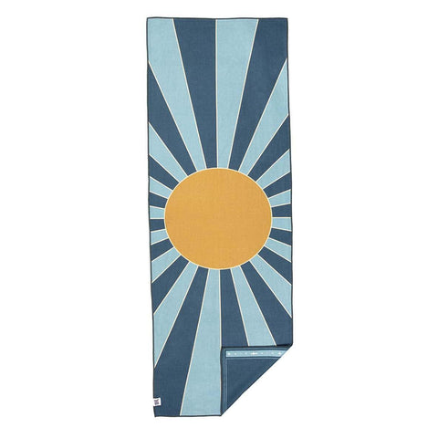 Trek Light towel with a vibrant sunburst design featuring blue rays and a golden circle, ideal for outdoor adventures.