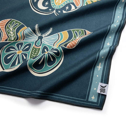 Colorful Trek Light blanket with intricate moth design and nature motifs, showcasing vibrant orange, blue, and green patterns.